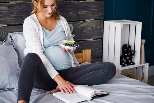 9 Foods to Avoid during pregnancy - Pregnant Woman eating in bed