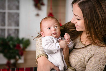 Young mother holding baby son and smiling